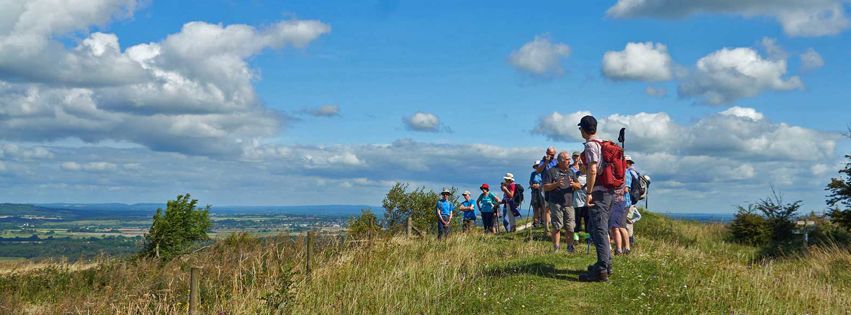 group of ramblers on top of a hill blue sky